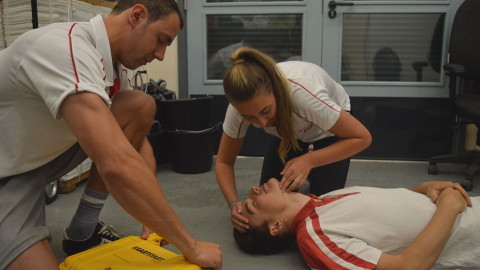Lifeguards performing first aid training with an AED